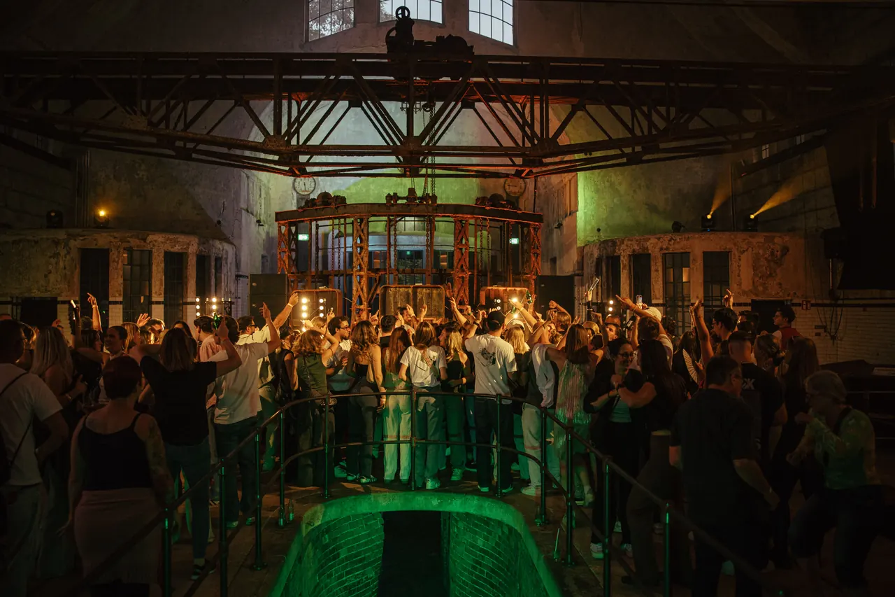 Feiernde Gäste unter der historischen Stahlkonstruktion der Klärhalle